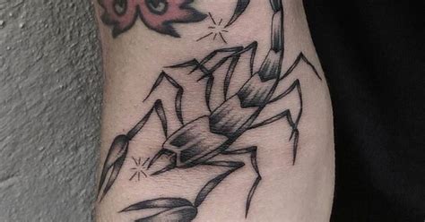 Scorpion tattoo on the right inner arm.