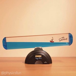 Surf’s Up Wave Machine https://physicsfunshop.com/search?keywords=surfs up Bart rides a surfboard between two immiscible liquids which are sorted under gravity by density with the densest (dyed water) on the bottom and the lightest (mineral oil) on top. Bart’s board has a density between that of the two liquids so it stays at the boundary layer, and a capsule of air above Bart’s head keeps him upright. The motorized rocking mechanism in the base is powered by one C cell battery and produces the 