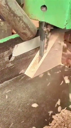 Worker drilling precise hole through wooden board using drill press