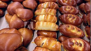 Baker displaying pastries products on bakery window for customer choice. Daily breakfast. Bakery products. An assortment of pastry products with puff pies rolls tarts and croissant