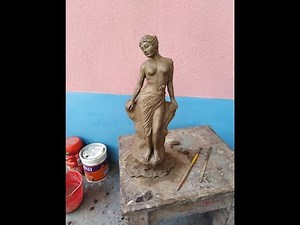 making clay statue of woman .