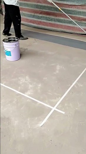 Applying Gray Epoxy Floor Coating to a Concrete Surface using a Paint Roller and White Masking Tape