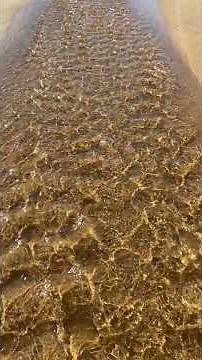 More beautiful ripples of water over sand making its way from a tide pool down the beach to th ocean