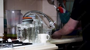 Washing dishes with soapy foam in small old kitchen time lapse and quickly moving