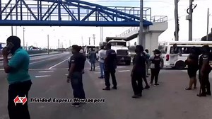WATCHING IT BURN: Police officers at the scene of a fiery protest action in Port-of-Spain on Monday afternoon. Express journalist Gyasi Gonzales is there. | Trinidad Express Newspapers