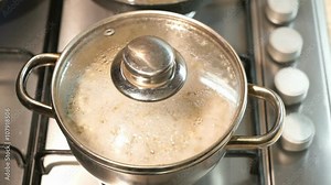 Cooking pearl-barley porridge on the stove