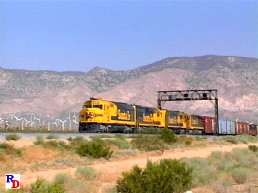 A Santa Fe eastbound drops downgrade as it nears Mojave, CA. From the WB Video Productions show on 2 discs "Tehachapi - 1988" https://rfd.video/T1988 #santafe #atsf #tehachapipass #tehachapipasswindfarm #mojaveca | Railfan Depot