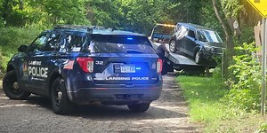 Large police presence surrounding crashed car in Lansing