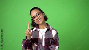 woman showing and lifting a finger in sign of the best on green screen chroma key background