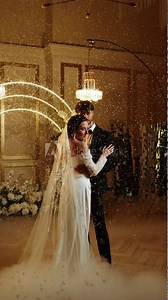 The bride and groom dance the first dance in the falling snow. Wedding day. Concept of the first wedding dance. Vertical video. 4k