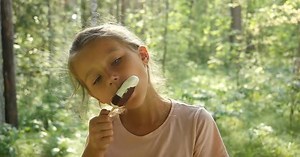 Kid Licking Ice-Cream. Charming Child Eats Ice Cream Outside. Little girl licking ice-cream.