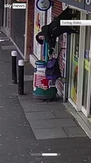 Woman lifted by shop shutters
