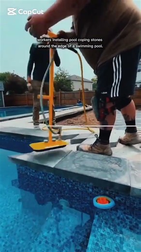 installing pool coping stones around the edge of a swimming pool.