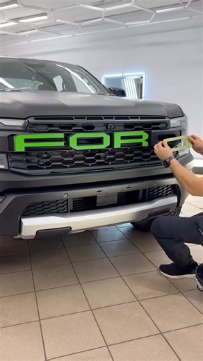 PolonezGarage on Instagram: "Extreme Contrast Mod 💚 | DIY Green Letter Wrap | Ford Raptor The Ford Ranger Raptor already has one of the most aggressive grilles on any truck — but we made it even bolder. 💚 In this unique customization, we wrap the massive F-O-R-D letters in bright green vinyl film, adding a sharp contrast to the fully matte black body. The result? A front that screams personality — and it’s 100% reversible. 📋 Step-by-step process: 🧵 Apply Painter’s Tape across the front lette