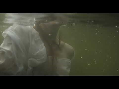 Footage Of A Woman swimming Underwater in a white dress