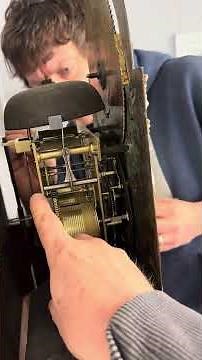 Oiling an 18th century antique grandfather clock movement.