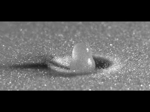 Slow motion water droplet impact on a sandy surface