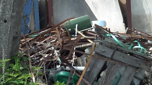 Dump site full of rusty metal trash and plastic waste behind a home house. Stinky heap of garbage. A pile of waste. Endless rubbish. Pollution concept. Polluted planet.