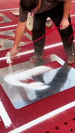 the process of spraying paint on a cement floor with the number 1 trace.