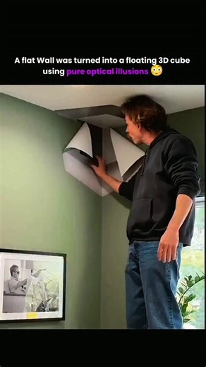 Knowledge Matrix on Instagram: "This is a trompe-l’œil anamorphic illusion, a classic illusion art technique designed to “trick the eye” into seeing three-dimensional objects on completely flat surfaces. In this video, the artist is applying a perspective-correct mural across two flat walls and the ceiling corner, carefully aligning angles, shadows, and highlights so that—when viewed from one precise viewpoint—the flat paint appears as a solid 3D cube floating out of the wall. The illusion works