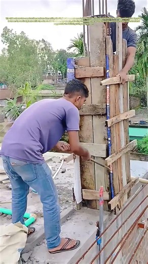Stripping the Shell: How Workers Pry Away the Wooden Mold from a Fresh Concrete Column