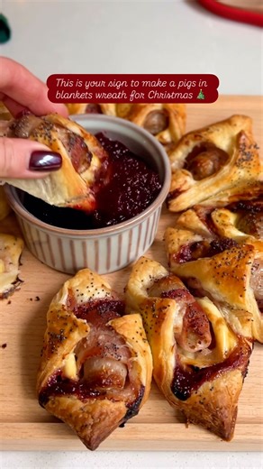 We’ve officially taken Christmas party food to the next level with this pigs in blankets wreath 🤯🎄 Get the recipe👇 INGREDIENTS - 11 pigs in blankets - 320g puff pastry - 100g brie, sliced into thin squares - 100g cranberry sauce, plus extra for serving - 1 egg, lightly whisked - 2 tbsp poppy seeds METHOD 1. Preheat your oven to 180°C. 2. On a floured surface, roll out the puff pastry to the thickness of a pound coin and cut into 11 even squares. 3. Spread a teaspoon of cranberry sauce and a s