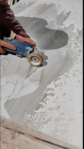 Using an angle grinder to carve patterns into a concrete surface
